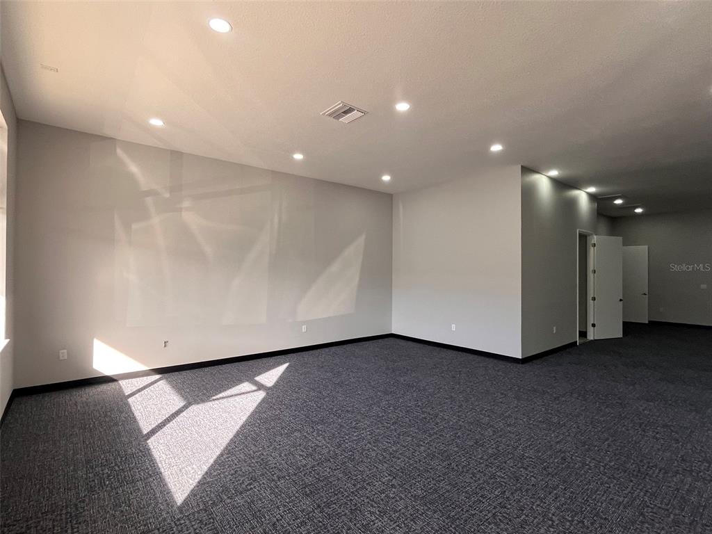 An empty office room with gray walls, dark carpet, and recessed ceiling lighting — 2019 21 STREET NW, WINTER HAVEN, FL