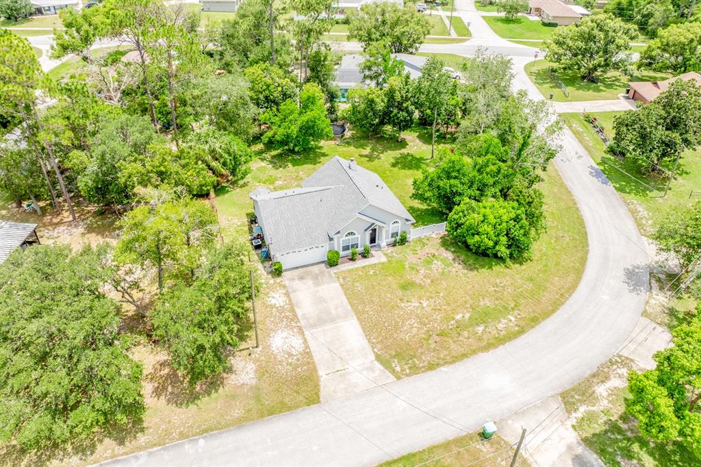 An aerial view shows a single-story house with a gray roof and concrete driveway — 2911 MALCOLM DRIVE, DELTONA, FL