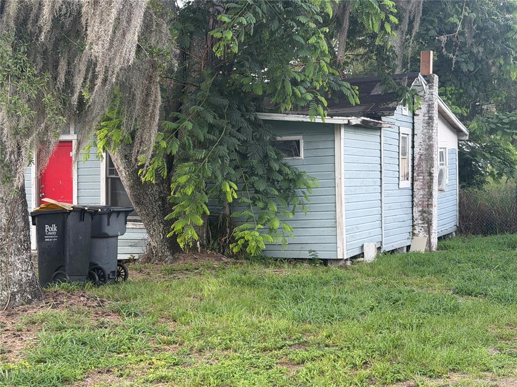 A small, light blue wooden house with a red door and a brick chimney — 2531 WEBER STREET, LAKELAND, FL