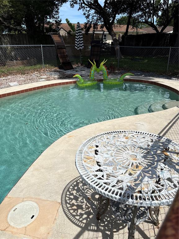 A backyard swimming pool with a decorative metal table and two inflatable dragon pool floats — 94 GLASS COURT, PORT ORANGE, FL
