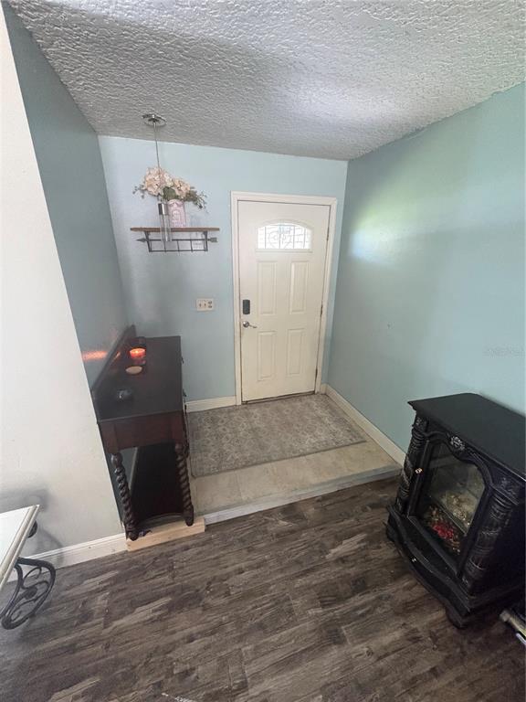 An entryway features a white front door, a dark wood console table, and a fireplace — 94 GLASS COURT, PORT ORANGE, FL