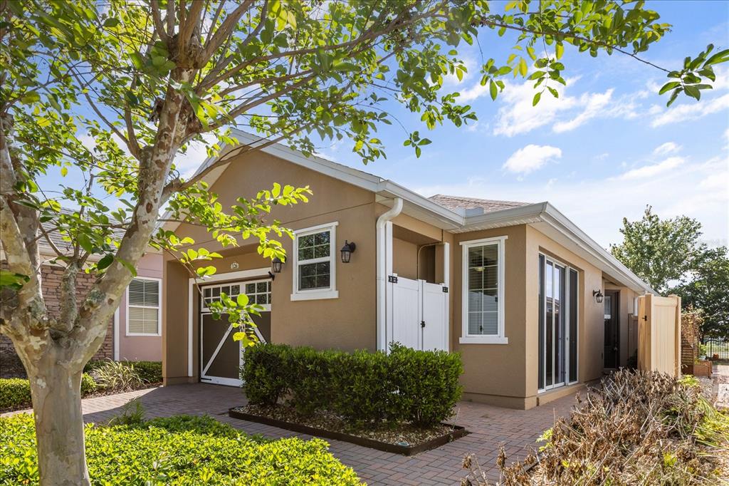 A tan single-story house with a brick paver driveway, a garage, and a small front yard — 126 BAYOU BEND ROAD, GROVELAND, FL