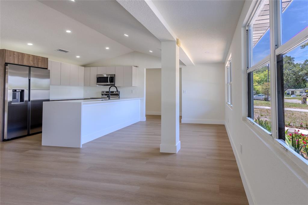 A modern kitchen features white cabinetry, a large island, and stainless steel appliances — 4502 S GRADY AVENUE, TAMPA, FL
