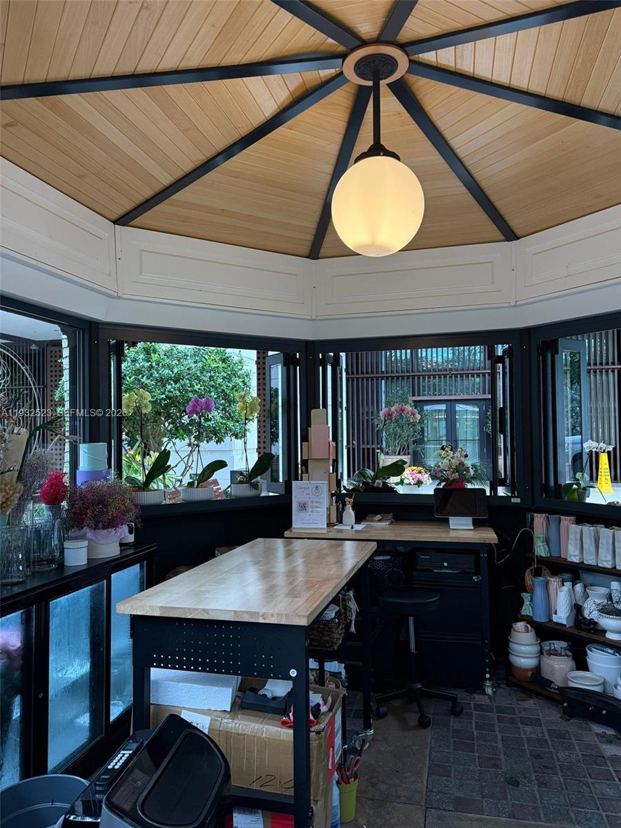 A small, hexagonal workspace features a wooden ceiling, a central pendant light, and large windows — 3011 Ponce de Leon Blvd, Coral Gables FL 33134, CORAL GABLES, FL