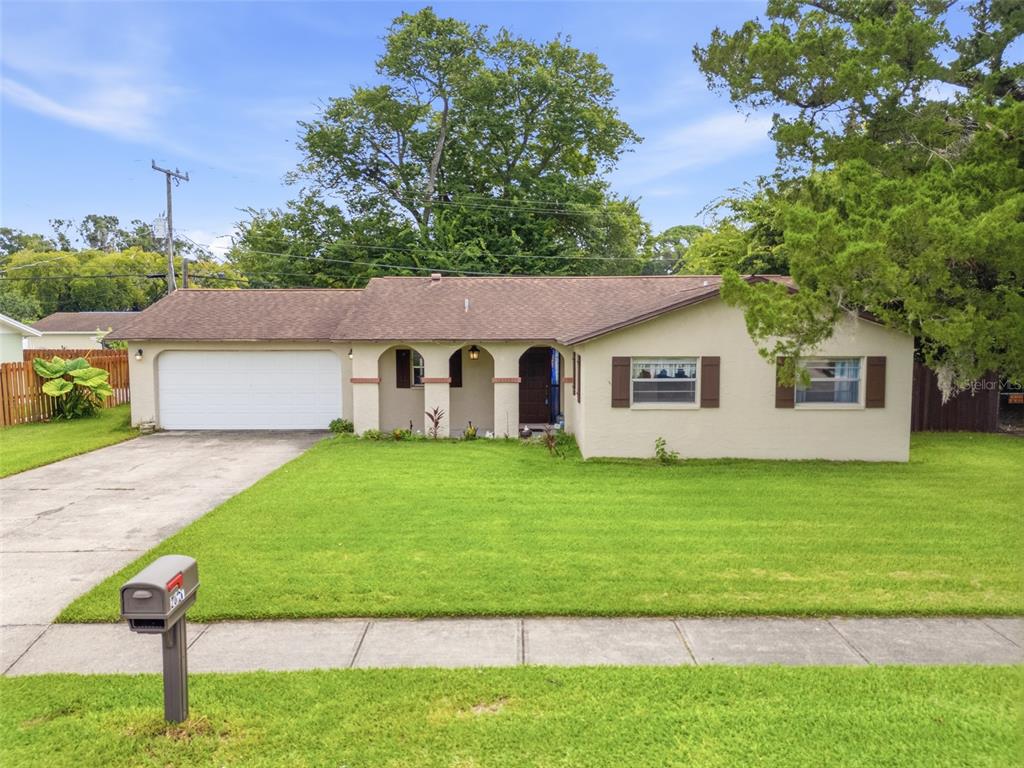 A single-story house with a white garage, arched entryway, and a green lawn — 2021 ORIOLE LANE, SOUTH DAYTONA, FL