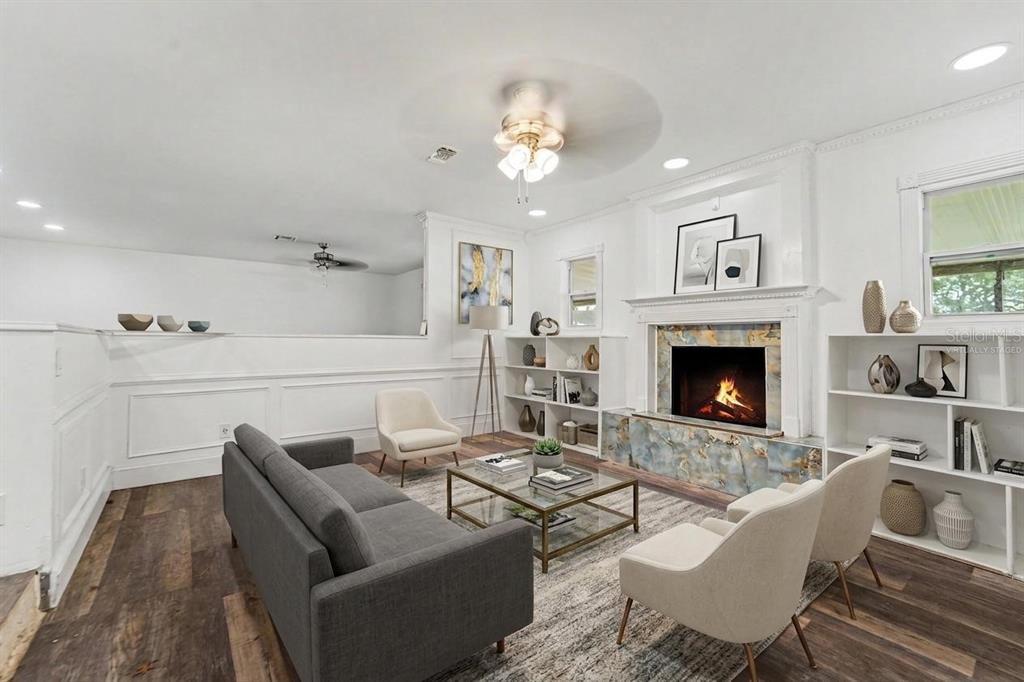A living room features a fireplace with blue marble, white built-in shelves, and wood flooring — 10938 SALT TREE DRIVE, PORT RICHEY, FL