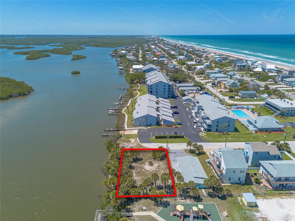 An aerial view shows a vacant, rectangular waterfront lot outlined in red next to buildings — 0 LADYFISH AVENUE, NEW SMYRNA BEACH, FL