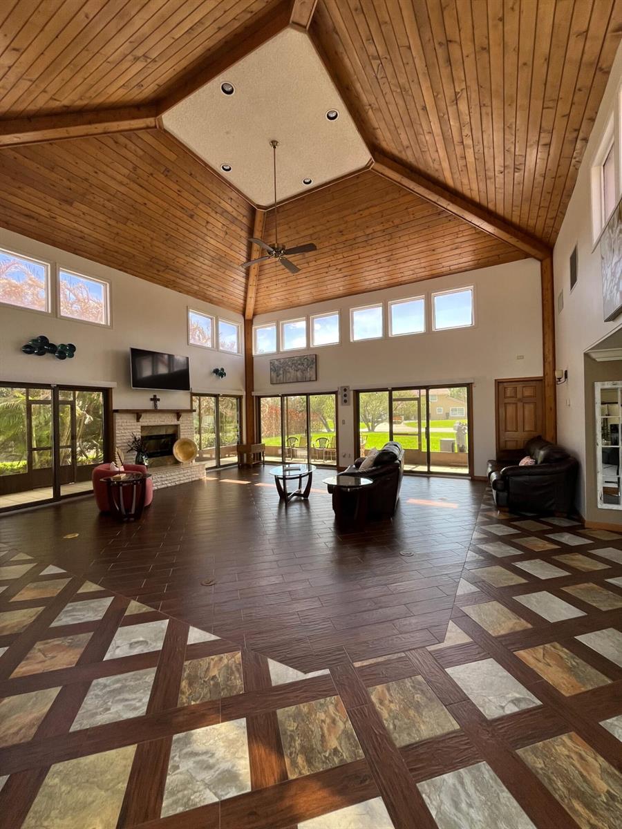 A spacious living room features a vaulted wood-paneled ceiling, tile flooring, and large glass doors — 2990 Conifer Drive, Fort Pierce FL 34951, FORT PIERCE, FL