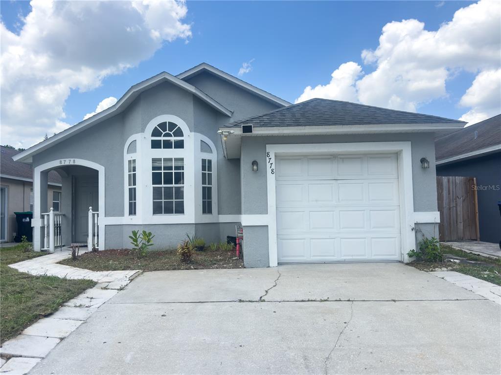 A single-story house with a gray stucco exterior, white trim, and a one-car garage — 8778 FOLEY DRIVE, ORLANDO, FL