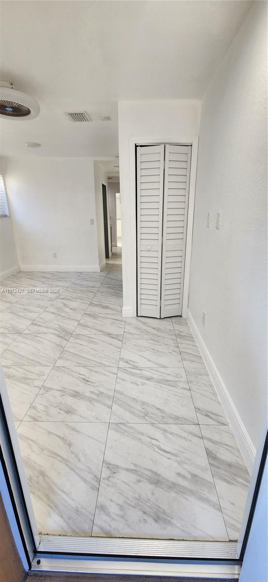 A room with white walls, light marble-patterned tile flooring, and a white louvered closet door — 1490/1492 NW 38th St, Miami FL 33142, MIAMI, FL