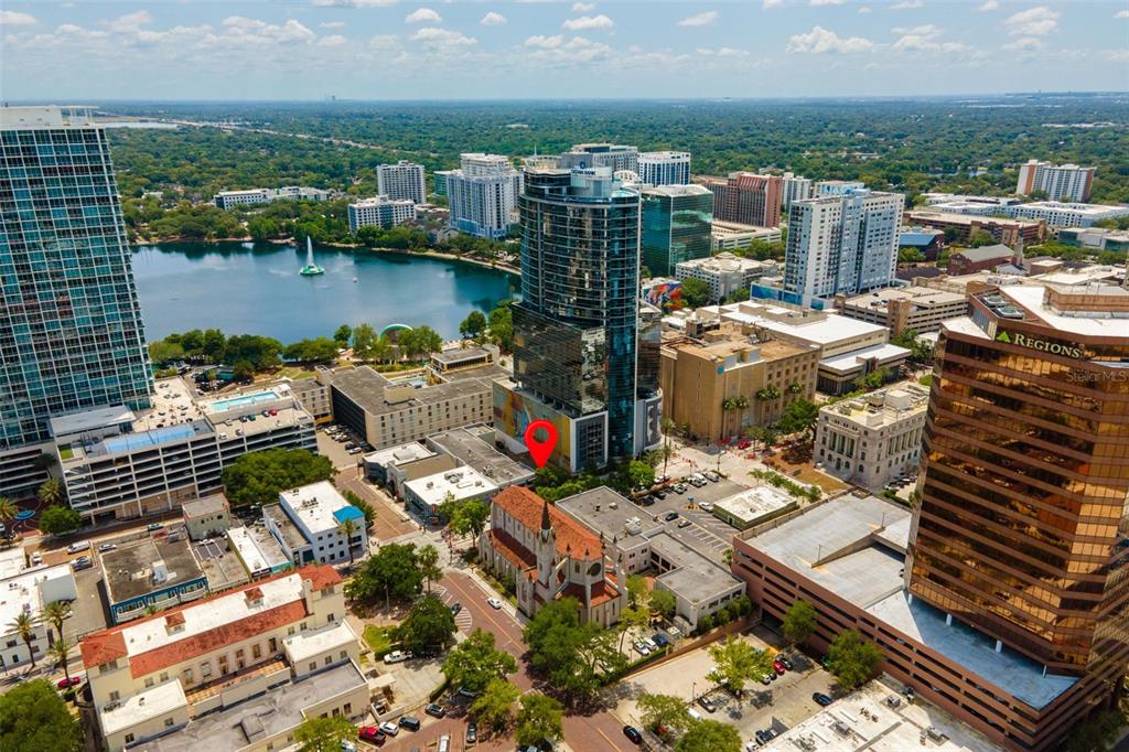 An aerial view of a city skyline featuring a lake, high-rise buildings, and a church — 127 N MAGNOLIA AVENUE, ORLANDO, FL