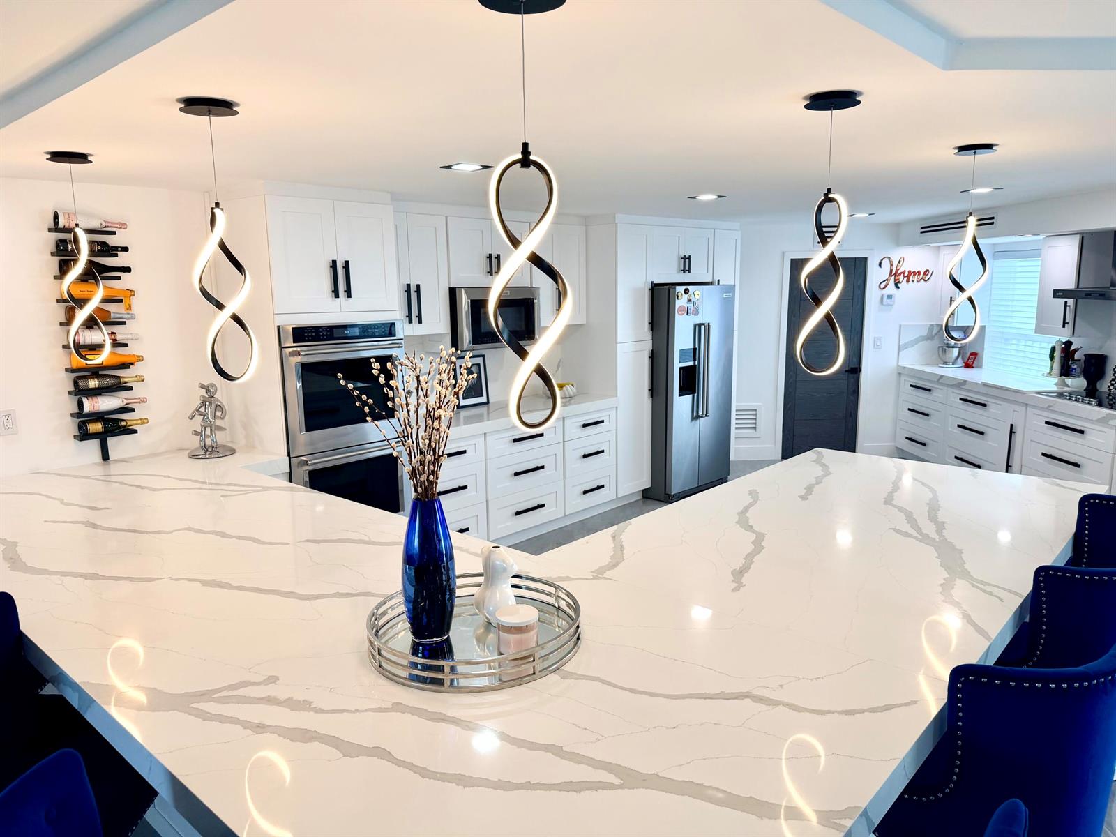 A modern kitchen features white cabinetry, stainless steel appliances, and polished gray tile flooring — 1627 Riverview Road # 615, Deerfield Beach FL 33441, DEERFIELD BEACH, FL