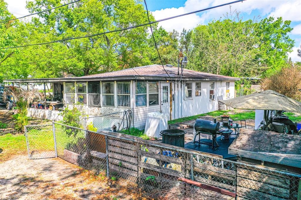 The exterior of a single-story house features a fenced yard, a patio, and a grill — 100 N SELF AVENUE, AVON PARK, FL
