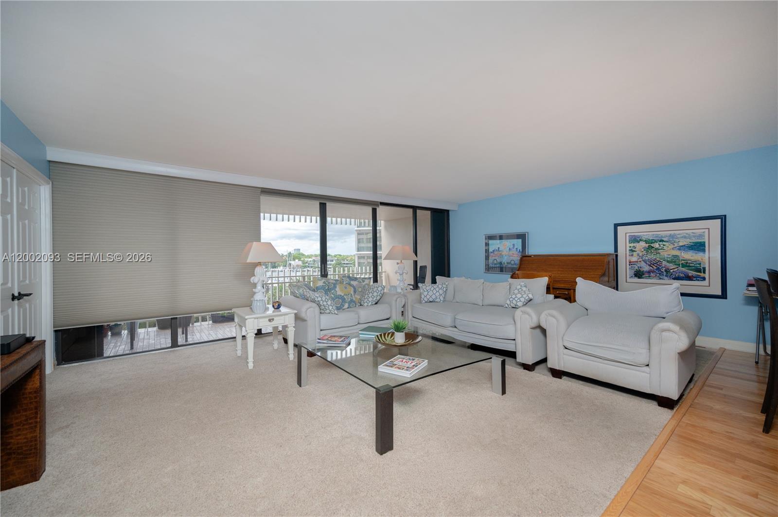 A living room features light blue walls, beige carpeting, white sofas, and a glass coffee table — 3 Grove Isle Dr # C308, Miami FL 33133, MIAMI, FL