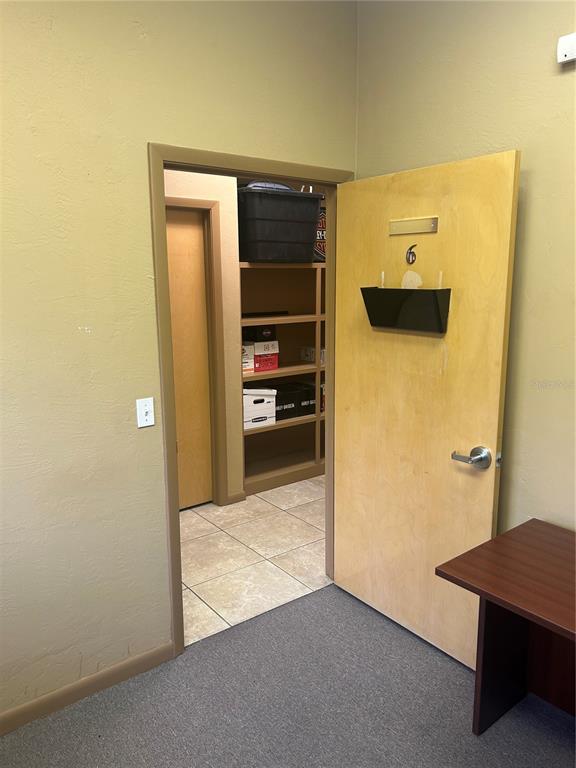 A doorway leads to a small storage room with shelves and a tile floor — 4031 NW 97TH BOULEVARD UNIT 6, GAINESVILLE, FL