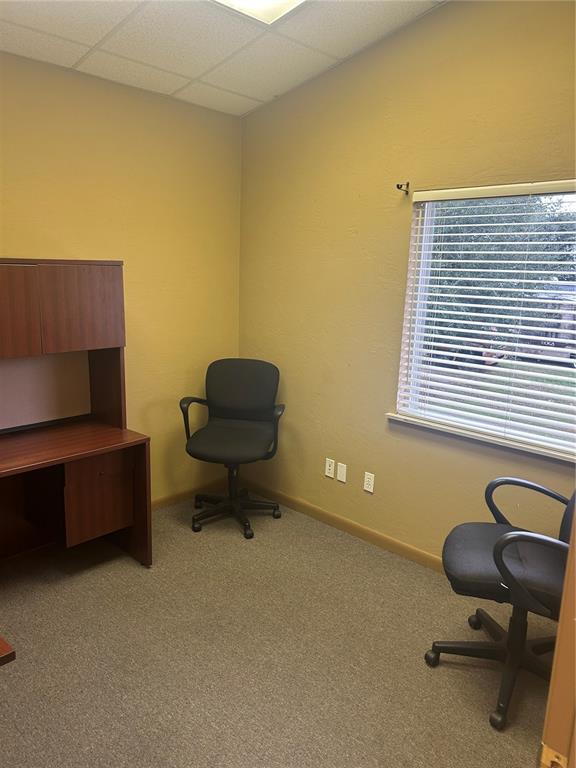 An office with tan walls, carpeted flooring, a wooden desk with hutch, and two chairs — 4031 NW 97TH BOULEVARD UNIT 6, GAINESVILLE, FL
