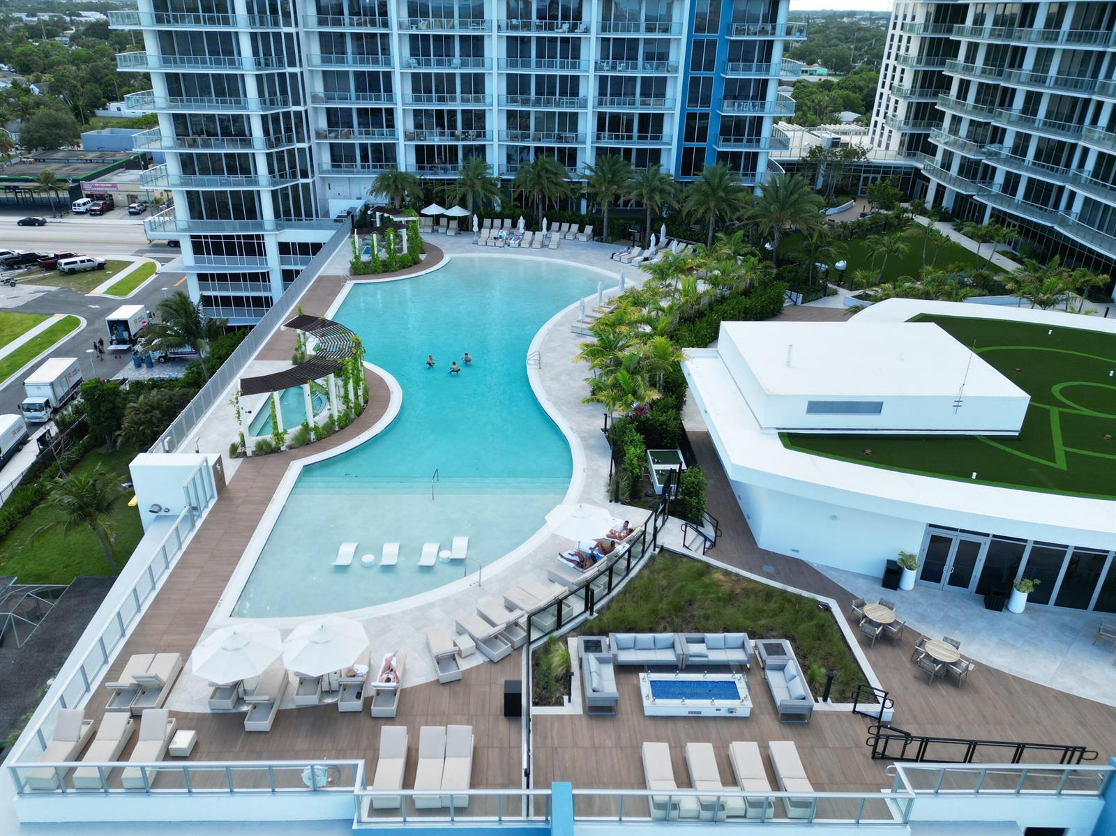 An aerial view shows a swimming pool with lounge chairs and a patio area — 220 Lake Shore Drive # 1908, Lake Park FL 33403, LAKE PARK, FL