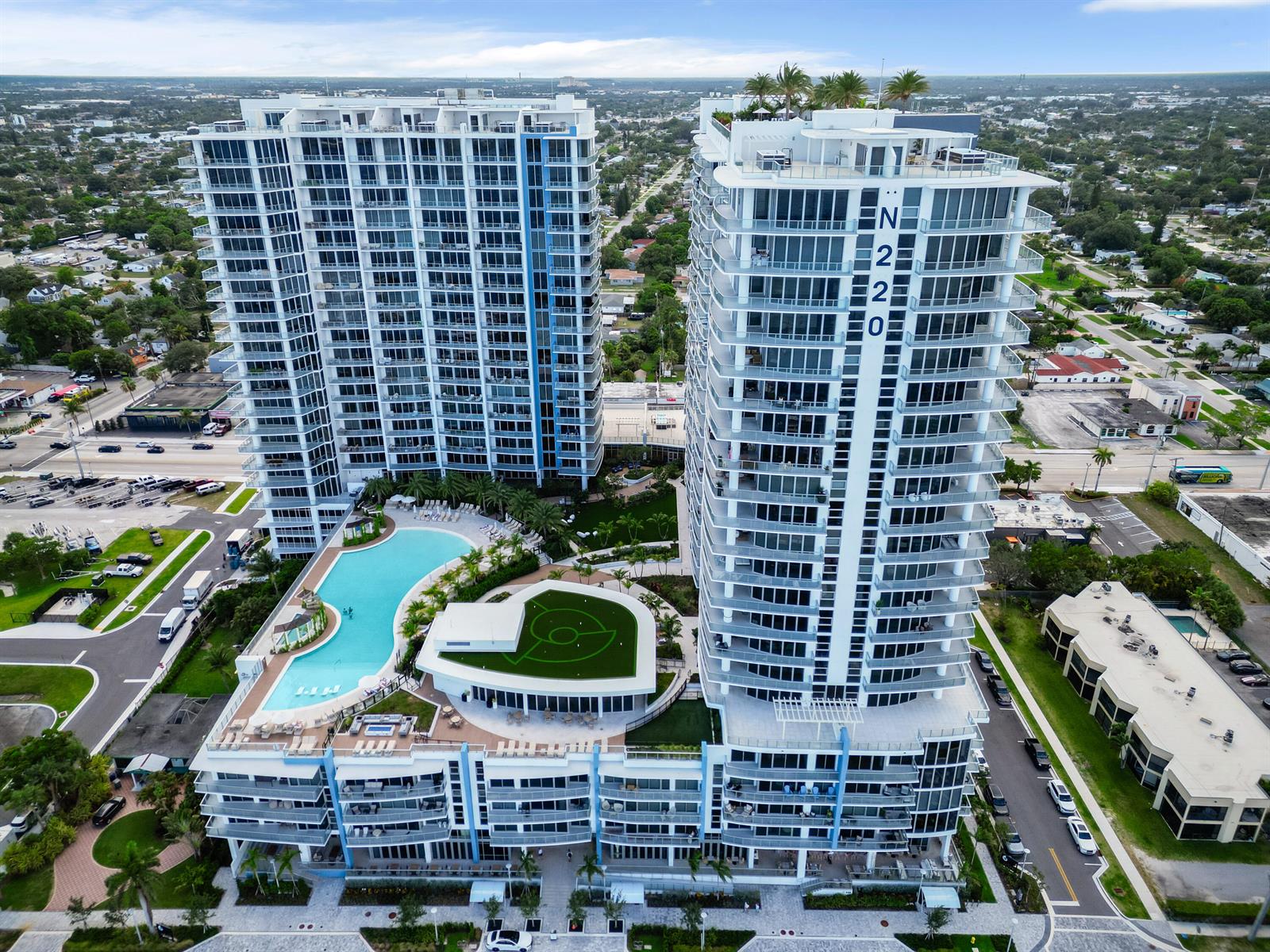 An aerial view shows two modern high-rise apartment buildings with a shared pool deck — 220 Lake Shore Drive # 1908, Lake Park FL 33403, LAKE PARK, FL