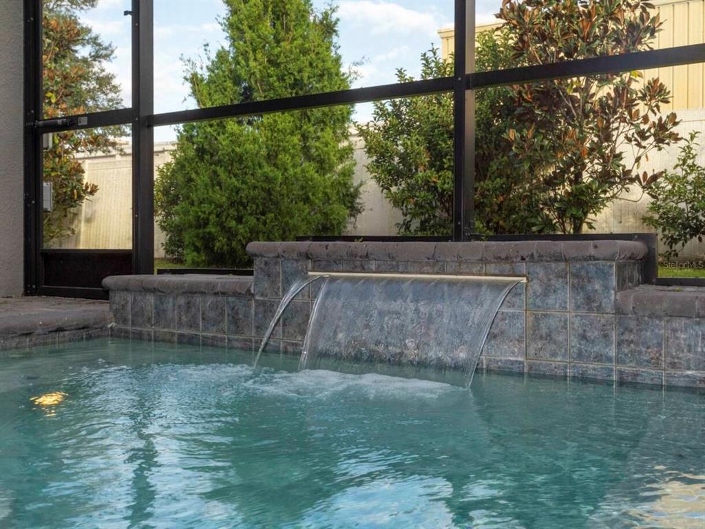 A swimming pool features a tiled water feature wall enclosed by a screened-in lanai — 4425 LE REVE COURT, KISSIMMEE, FL