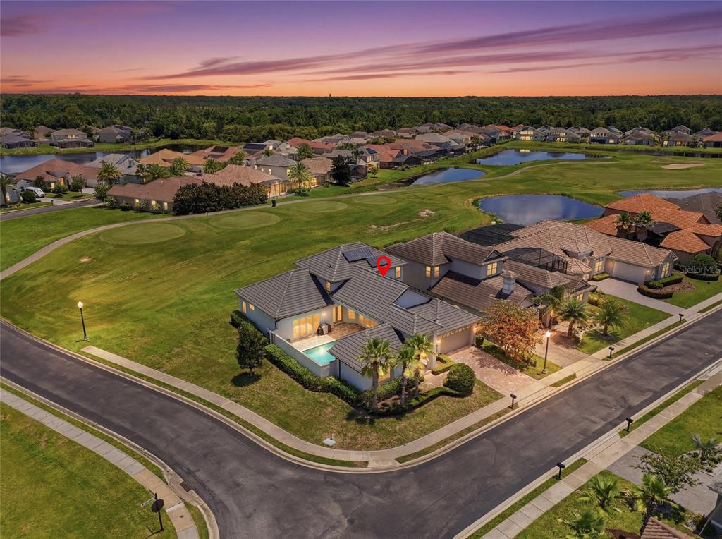 An aerial view shows a residential house with a pool and solar panels on the roof — 2562 HERITAGE GREEN AVENUE, DAVENPORT, FL