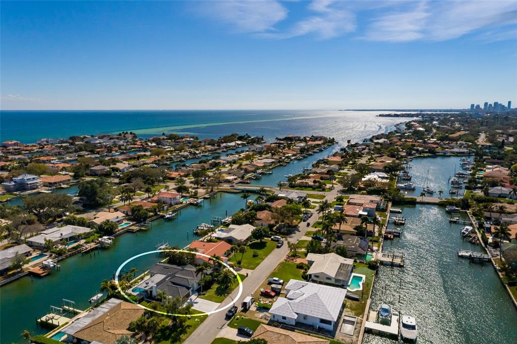 A swimming pool with a sun shelf overlooks a canal with a private boat dock — 2032 KANSAS AVENUE NE, ST PETERSBURG, FL