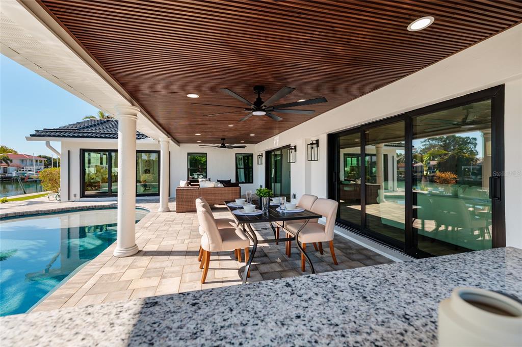 A white house with a boat dock sits along a canal under a blue sky — 2032 KANSAS AVENUE NE, ST PETERSBURG, FL