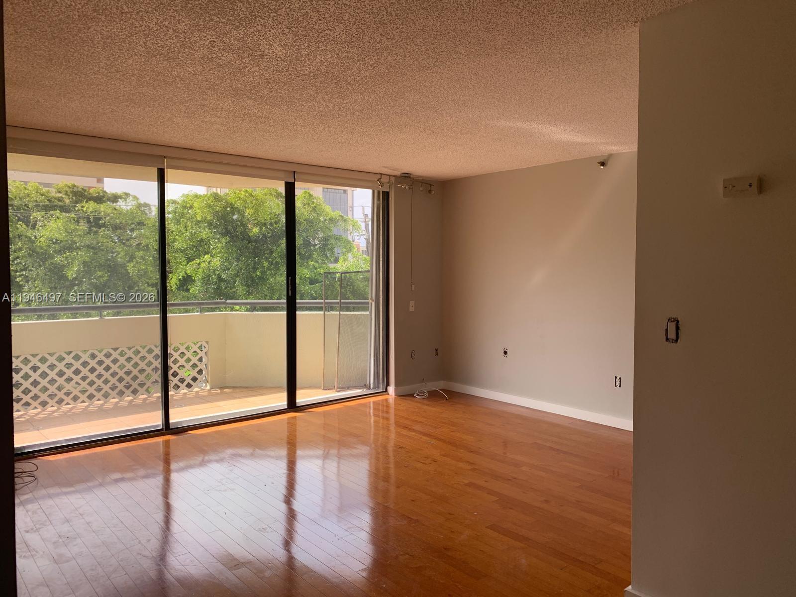 A bathroom features a glass vessel sink, a round backlit mirror, and mosaic tile walls — 911 E Ponce De Leon Blvd # 403, Coral Gables FL 33134, CORAL GABLES, FL