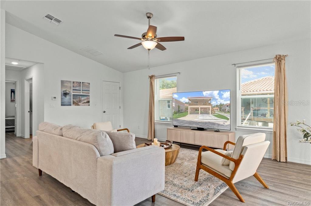 A living room features a beige sofa, two armchairs, a television, and a ceiling fan — 4864 S AMSTEL DRIVE, HOMOSASSA, FL