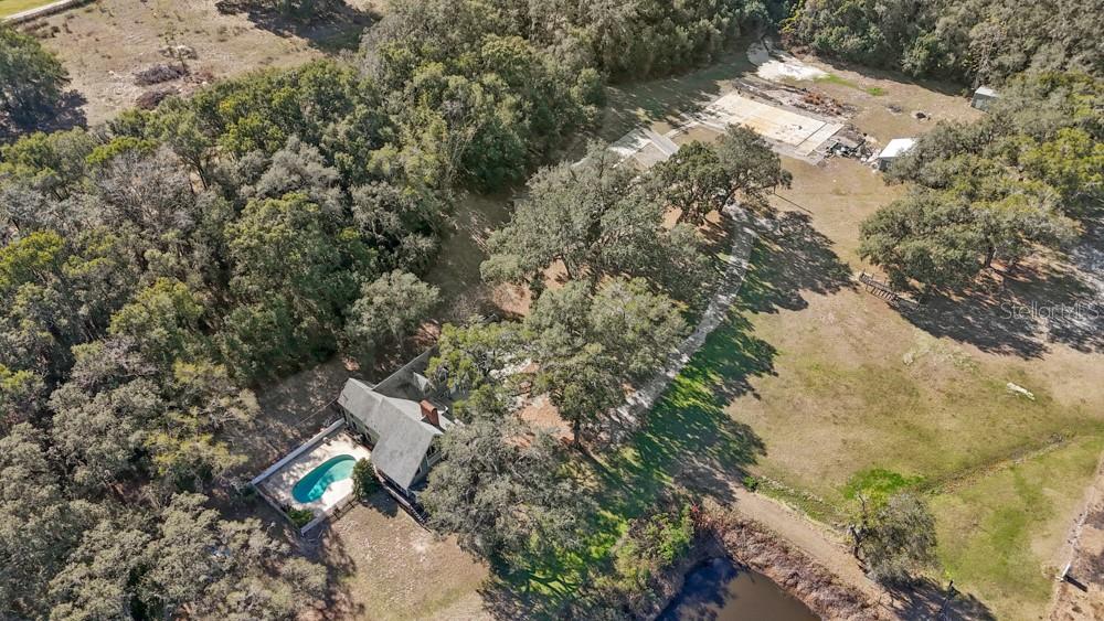 An aerial view shows a house with a pool, surrounded by trees and open land — 19621 LAKE LINCOLN LANE, EUSTIS, FL
