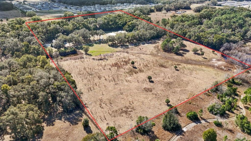 An aerial view shows a large, rectangular plot of land with trees and open fields — 19621 LAKE LINCOLN LANE, EUSTIS, FL