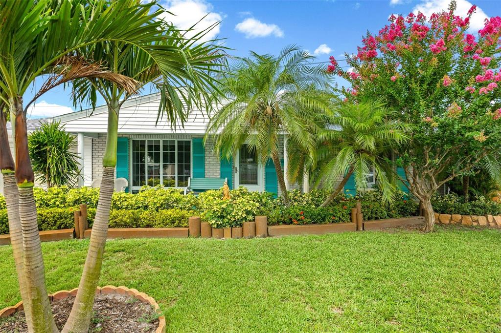 A single-story house with turquoise shutters, palm trees, and a blooming crape myrtle tree — 2545 EDNOR STREET, PORT CHARLOTTE, FL