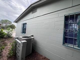 The exterior side of a light green concrete block house features an air conditioning unit — 4219 5TH AVENUE N, ST PETERSBURG, FL