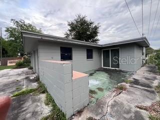 The exterior of a gray house features a concrete block wall and a cracked patio — 4219 5TH AVENUE N, ST PETERSBURG, FL