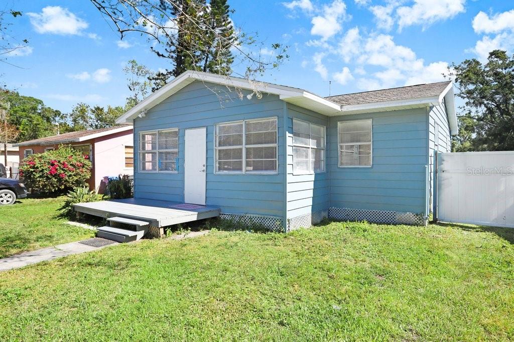 A blue, single-story house with a wooden front deck and white trim — 10414 RICHARDSON STREET, GIBSONTON, FL