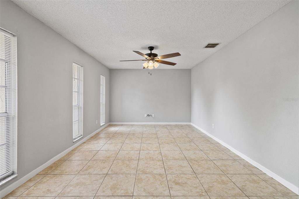 An empty room with light gray walls, beige tile flooring, and a ceiling fan — 4035 WENDY DRIVE, ORLANDO, FL