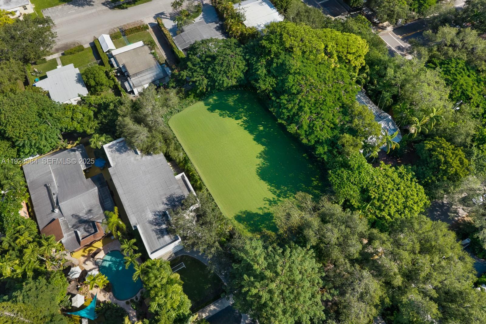 An aerial view shows a residential property with a large green lawn and swimming pool — 3729 Kumquat Ave, Miami FL 33133, MIAMI, FL