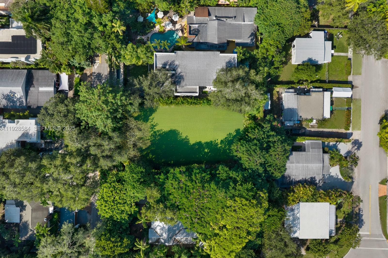 An aerial view shows a residential property with a large green lawn and swimming pool — 3729 Kumquat Ave, Miami FL 33133, MIAMI, FL