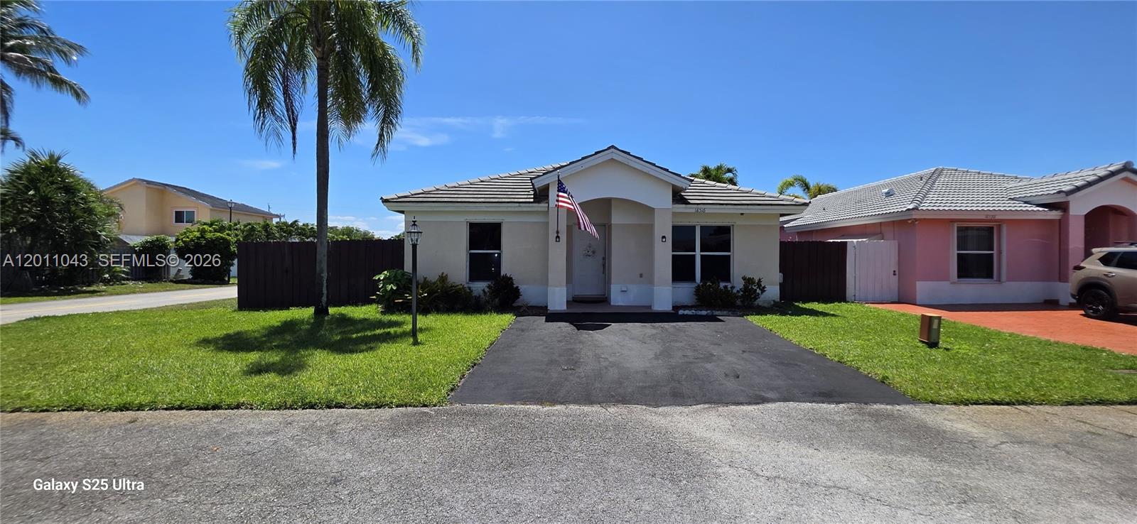 A single-story house with a tan exterior, a dark roof, and a paved driveway — 18516 NW 56th Ave, Miami Gardens FL 33055, MIAMI GARDENS, FL