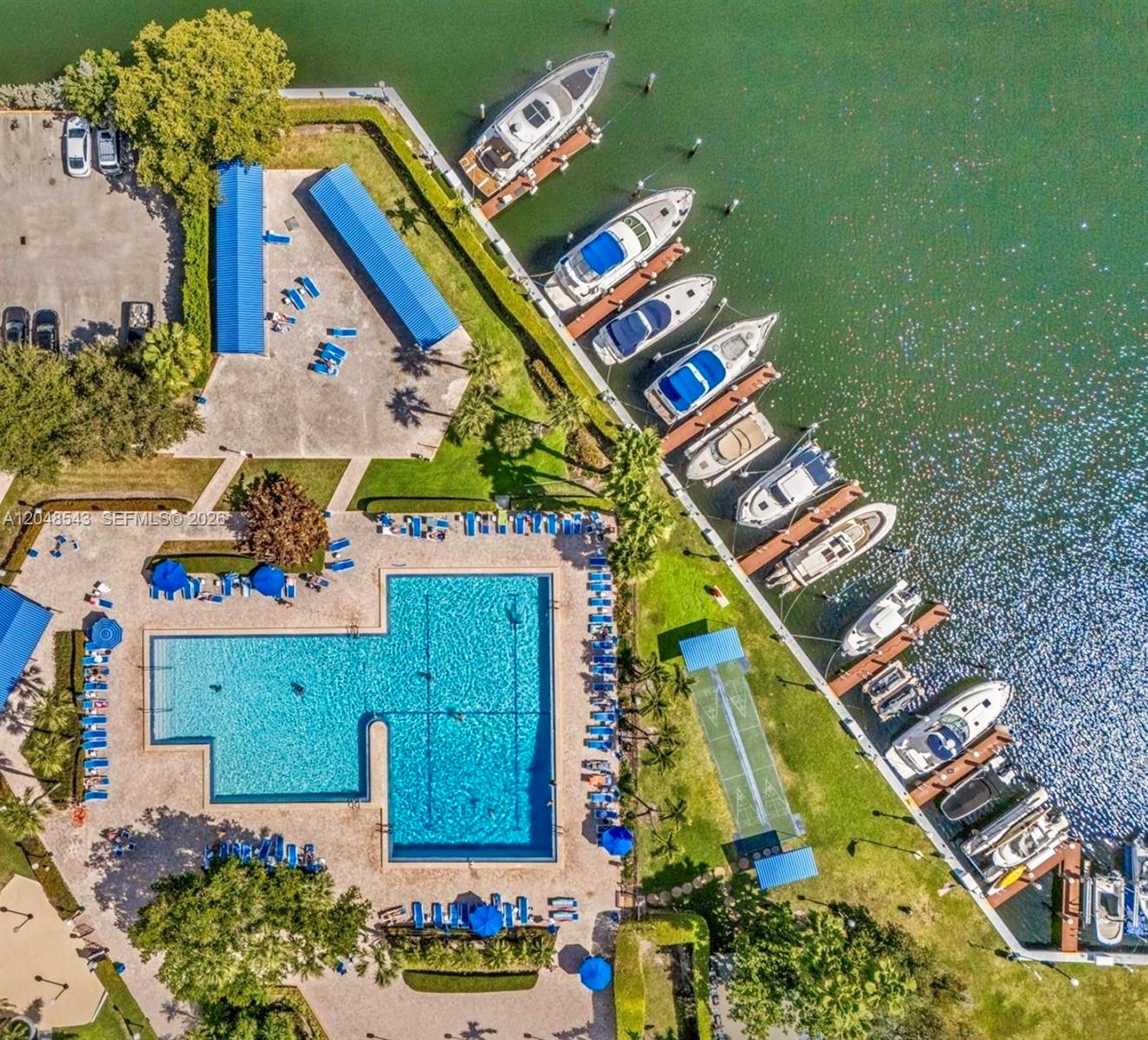 An aerial view shows a swimming pool, a marina with docked boats, and parking — 500 Three Islands Blvd # L25, Hallandale Beach FL 33009, HALLANDALE BEACH, FL