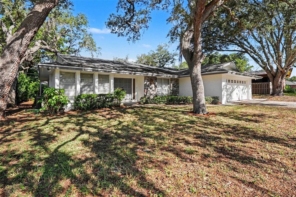 A single-story house with a white exterior, stone accents, and a two-car garage — 209 15TH STREET, PALM HARBOR, FL