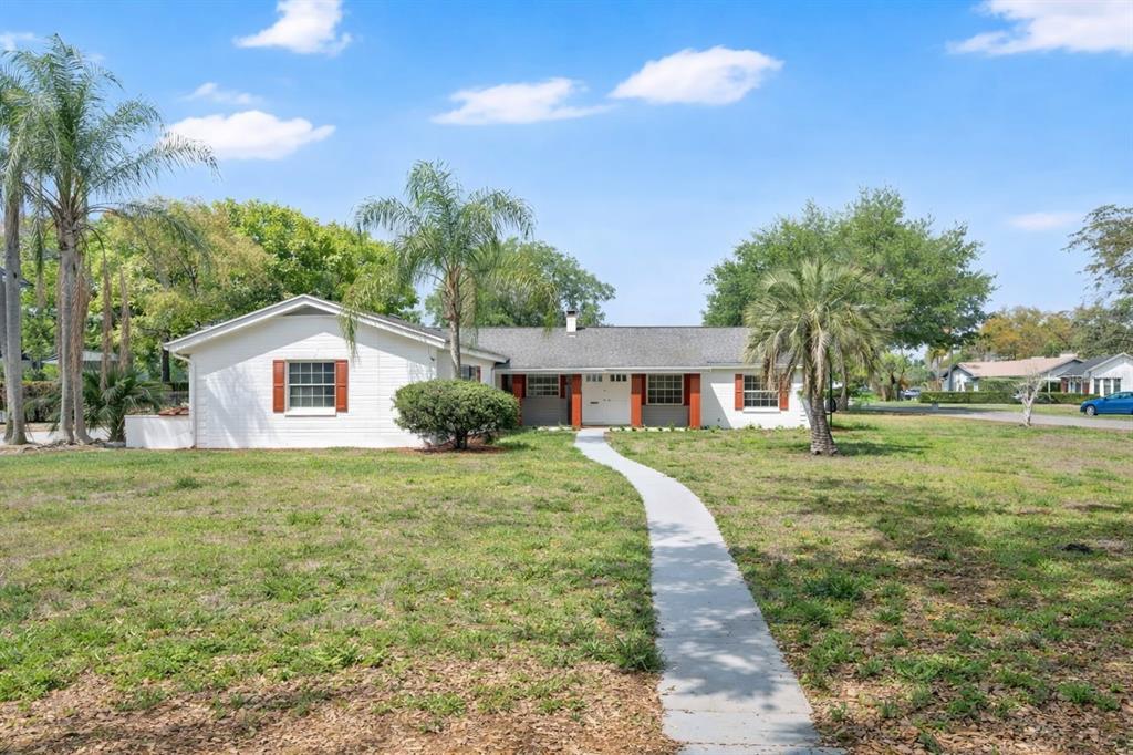 A white, single-story house with a gray roof and a concrete walkway in the yard — 1241 MANCHESTER ROAD, MAITLAND, FL