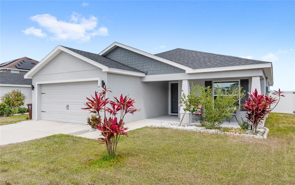 A single-story house with a gray exterior, a two-car garage, and a covered front porch — 4215 SWAN STREET, HAINES CITY, FL