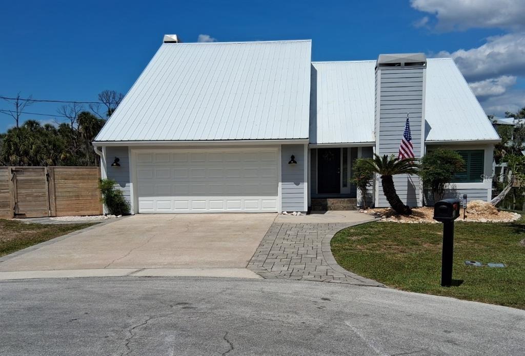 A light blue house with a white metal roof and a paved walkway — 8720 BETTY STREET, PORT RICHEY, FL