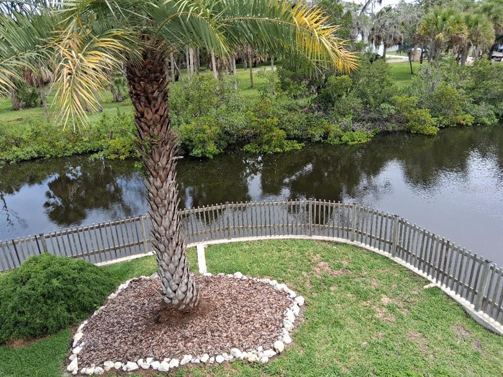 A canal view shows a wooden gazebo, a boat lift with a covered boat, and fencing — 8720 BETTY STREET, PORT RICHEY, FL