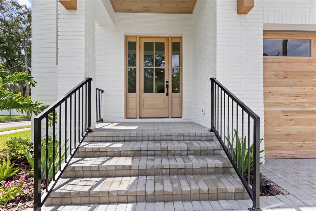 A front entrance features brick steps, black metal railings, and a light wood front door — 4302 W OBISPO STREET, TAMPA, FL