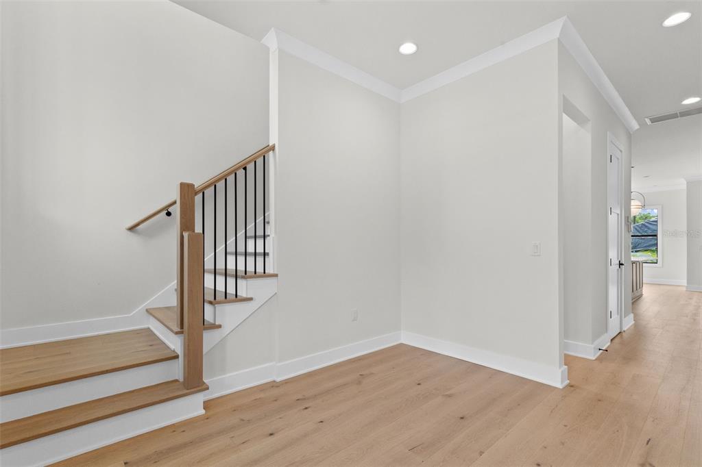 A staircase with wooden treads and black railings stands in a room with light flooring — 4302 W OBISPO STREET, TAMPA, FL