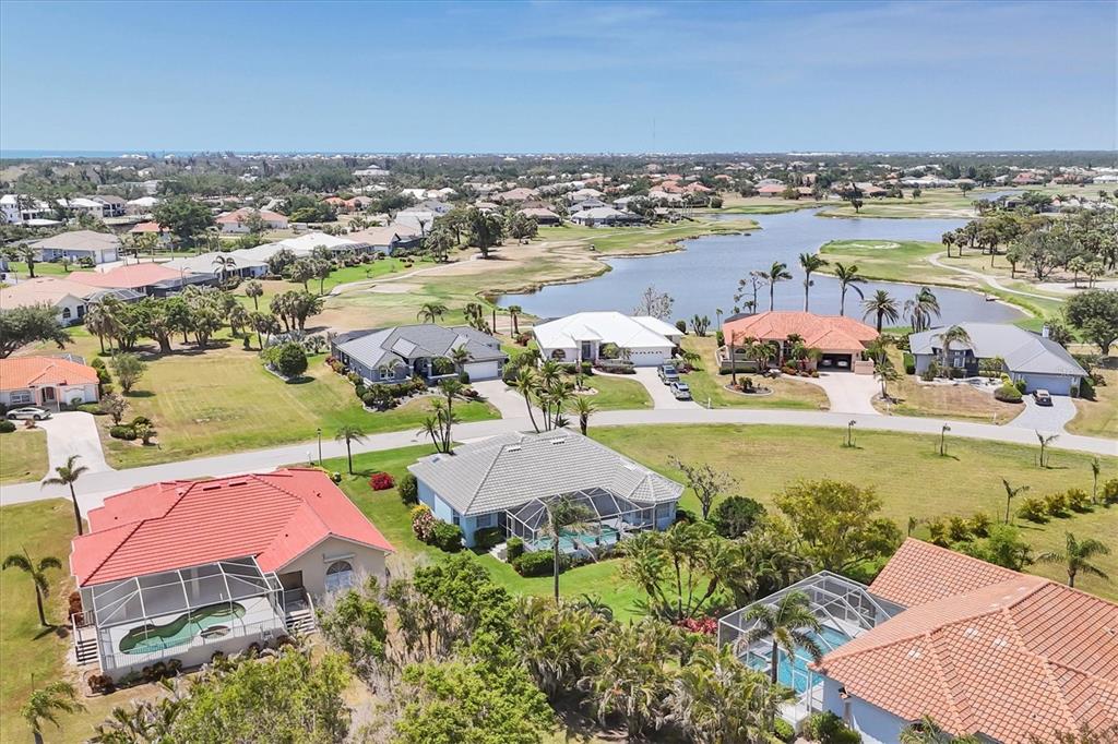 An aerial view of a suburban neighborhood featuring houses with pools near a lake — 11 AMBERJACK LANE, PLACIDA, FL