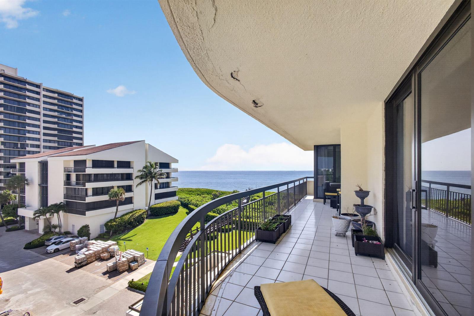 A tiled balcony overlooks a grassy lawn, a neighboring building, and the ocean — 4000 N Ocean Drive # 403, Singer Island FL 33404, SINGER ISLAND, FL
