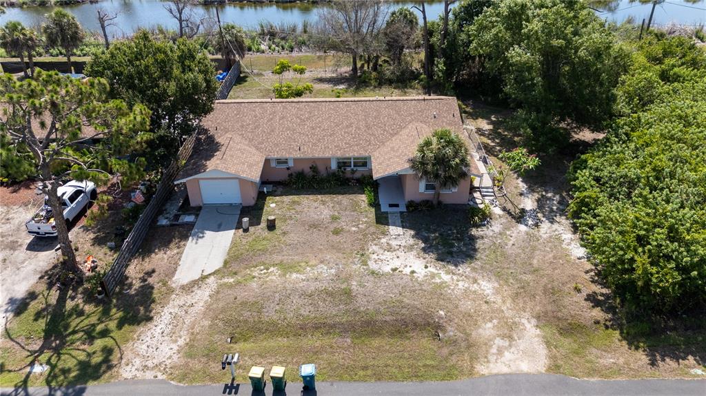 An aerial view shows a single-story house with a brown roof and a sandy yard — 1825 SHADOW LANE, ENGLEWOOD, FL