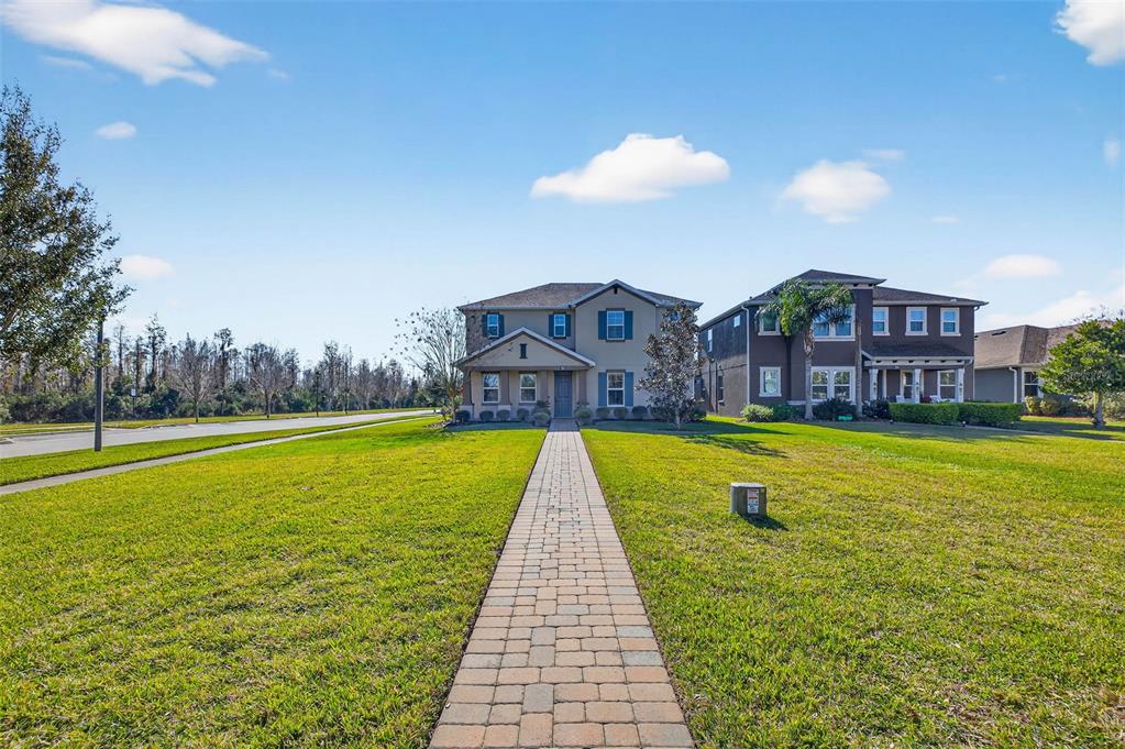 A paved walkway leads to the front entrance of two adjacent two-story suburban houses — 17268 BRIGHTON LAKE ROAD, LAND O LAKES, FL